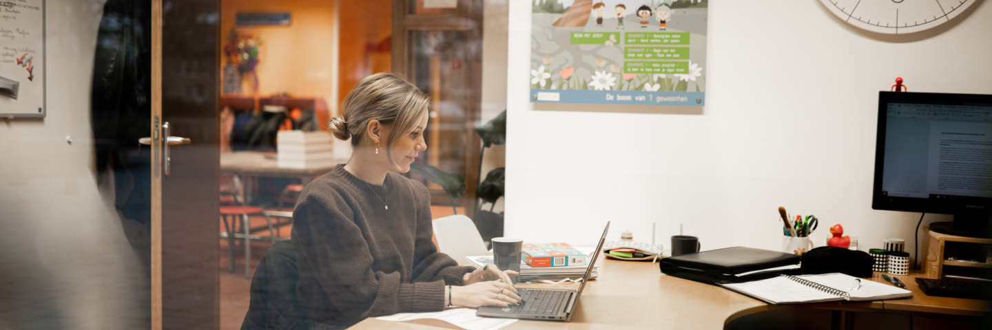 Docent werkt op laptop